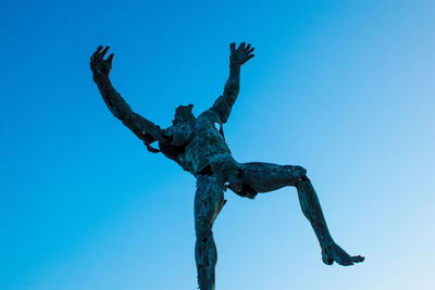 Low angle view of statue against clear blue sky