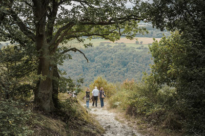 Rear view of woman walking on dirt road