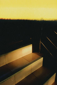 High angle view of table against yellow wall at night