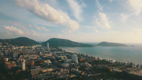 High angle view of city by sea against sky