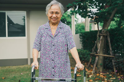 Portrait of smiling woman standing in yard