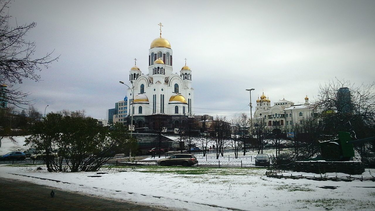 building exterior, architecture, built structure, sky, tree, street, car, church, snow, winter, transportation, land vehicle, season, weather, road, cold temperature, religion, day, house, city