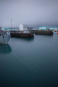 View of harbor in city against clear sky