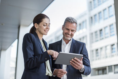 Portrait of two business partners looking together at tablet