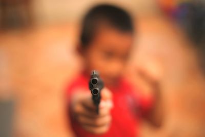 Close-up of boy shooting with toy gun