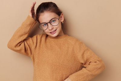 Close-up portrait of young woman against wall