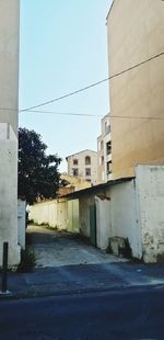 Empty road amidst buildings against sky