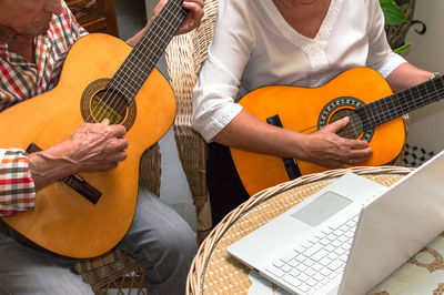 Midsection of man playing guitar