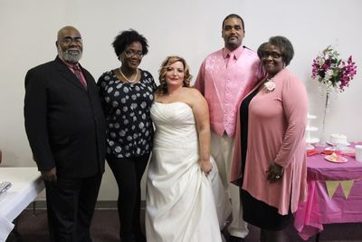 Portrait of family standing with wedding couple by wall