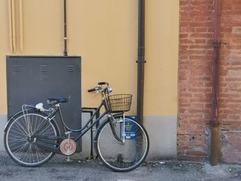 Bicycle parked on wall by building