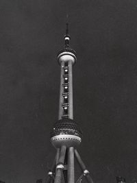 Low angle view of communications tower in city against sky