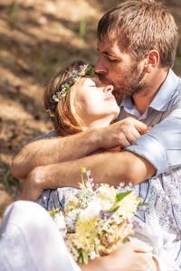 Midsection of man and woman holding flower bouquet