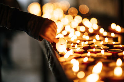 Cropped hand of person holding candle in church