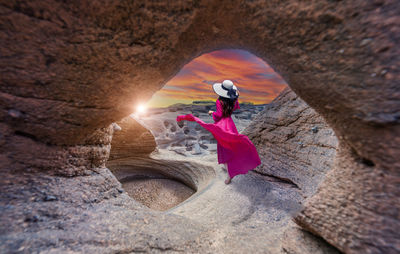 Rear view of woman standing on rock