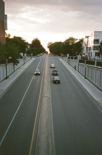 Cars on road in city at sunset