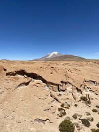 Scenic view of desert against clear blue sky