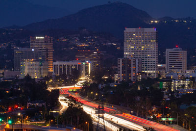 High angle view of illuminated city street and buildings at night