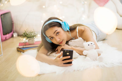 Portrait of young woman using mobile phone at home