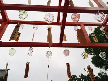 Low angle view of lanterns hanging against sky