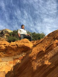 Portrait of young man sitting on mountain