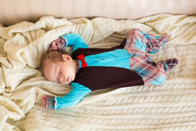 High angle view of boy sleeping on bed