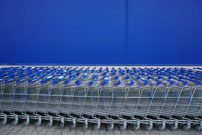 Shopping trolleys arranged against blue wall