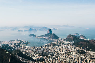 High angle view of city by sea against sky