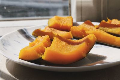 Close-up of orange slices in plate on table