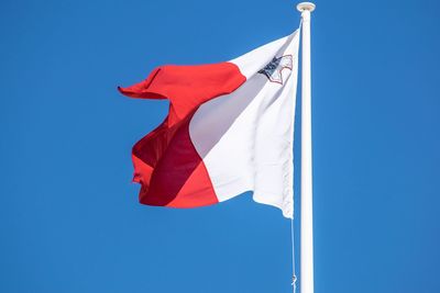 Low angle view of flag against blue sky