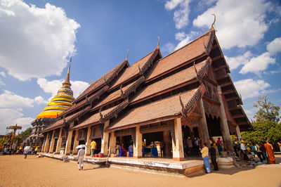 Group of people outside building against sky