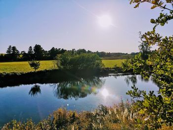 Scenic view of lake against sky on sunny day