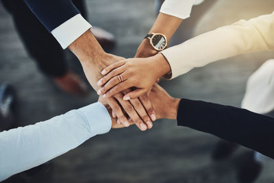 Cropped image of business people stacking hands