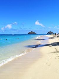 Scenic view of beach against blue sky