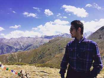 Full length of man with arms raised on mountain against sky