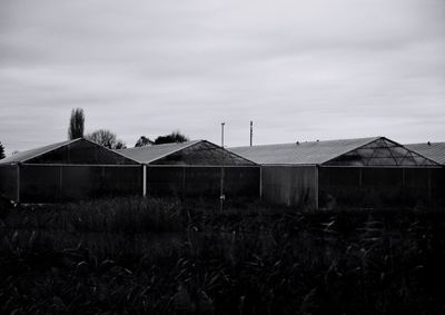 Houses in farm against sky