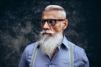 Close-up of senior hipster against wall