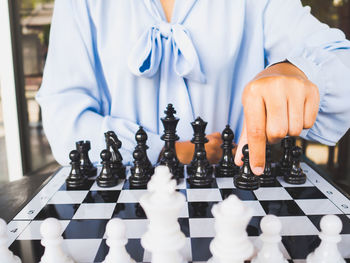 Midsection of woman playing on chess board