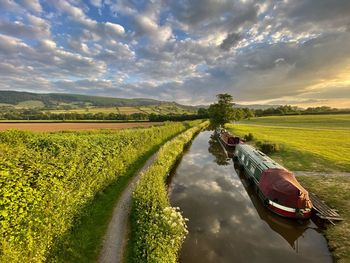 Scenic view of river barges against sky during sunset