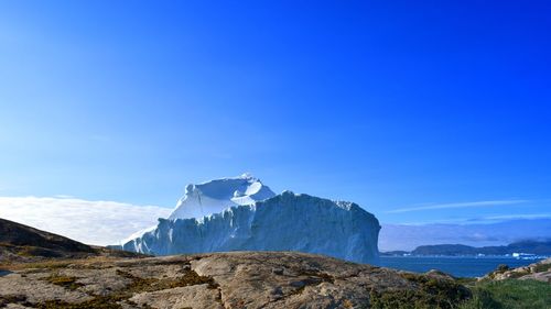 Scenic view of snowcapped mountain against blue sky