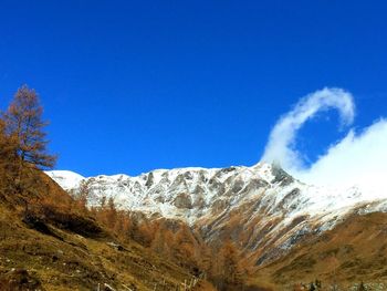 Low angle view of mountain against blue sky