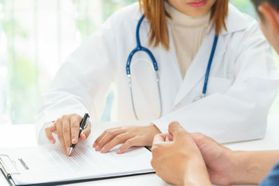 Midsection of woman with text on table