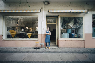 Portrait of confident male upholstery worker standing at workshop entrance