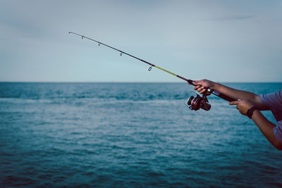 Fishing rod wheel closeup, man fishing from the boat in the sea.