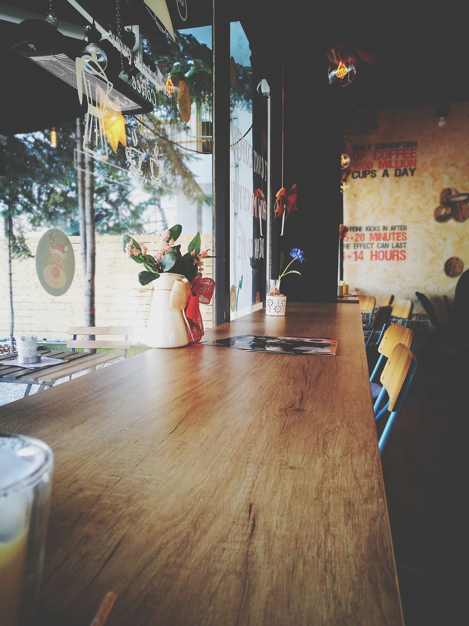 REAR VIEW OF MAN STANDING BY GLASS TABLE IN RESTAURANT