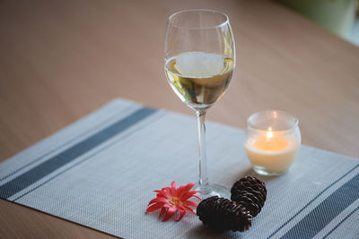 Pine cones and candle with wine on fabric