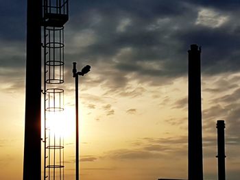 Silhouette pole against sky at sunset