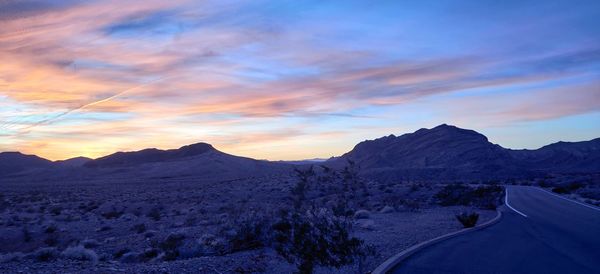 Scenic view of snowcapped mountains against sky during sunset