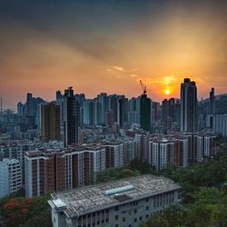 Modern buildings against sky during sunset