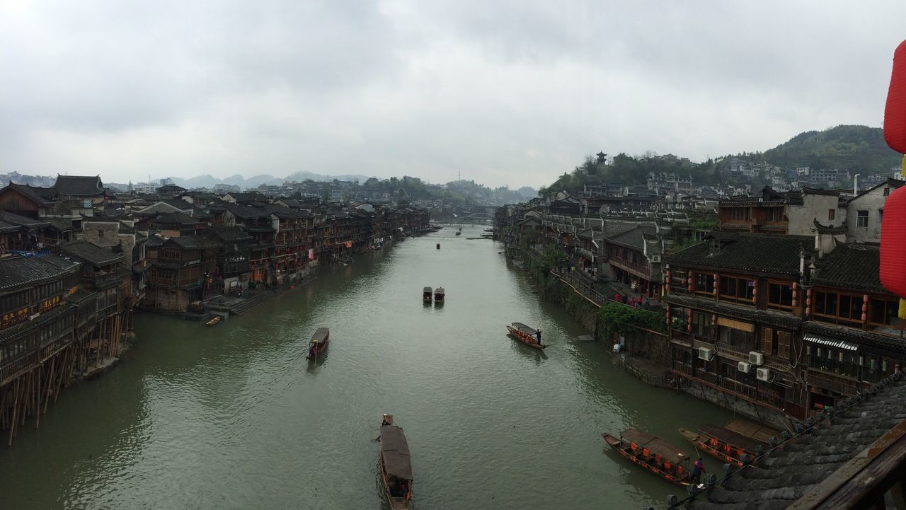 architecture, building exterior, built structure, water, city, sky, nautical vessel, river, transportation, high angle view, cityscape, residential structure, residential district, waterfront, boat, cloud - sky, residential building, canal, town, mode of transport