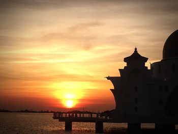 Silhouette of building against cloudy sky during sunset